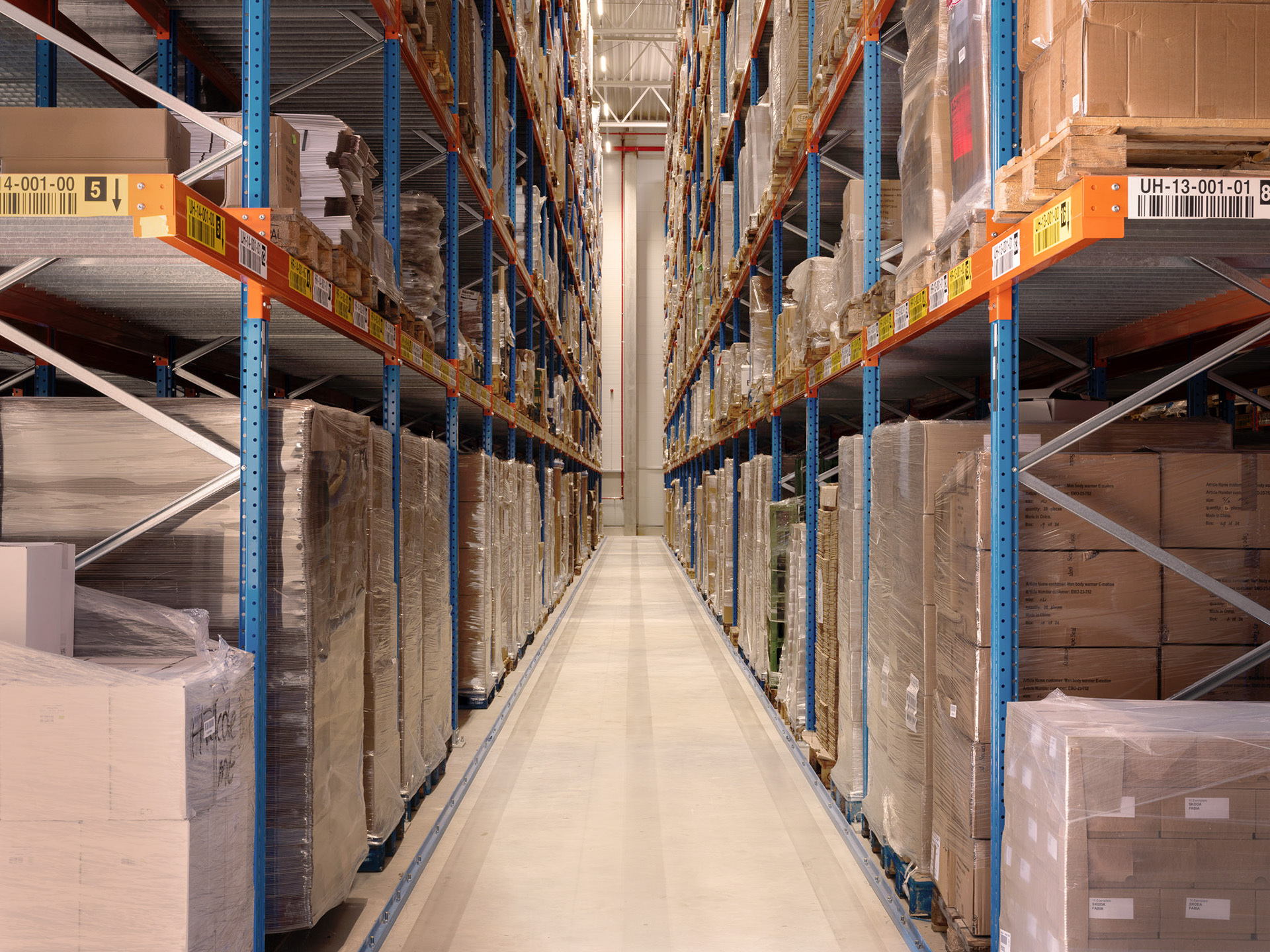 Ein modernes Lager mit Regalen voller verpackter Waren, das die logistische Abwicklung von Marketing- und Kampagnenprojekten durch Greim Projekt Service veranschaulicht.
